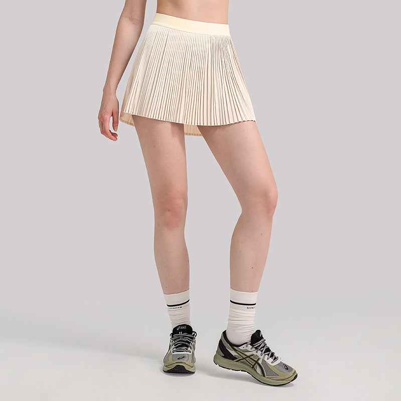 Agile Pleated Lightweight Tennis Skirt with Built-In & Safety Shorts in cream, featuring high-stretch waistband and breathable pleats for activewear comfort.