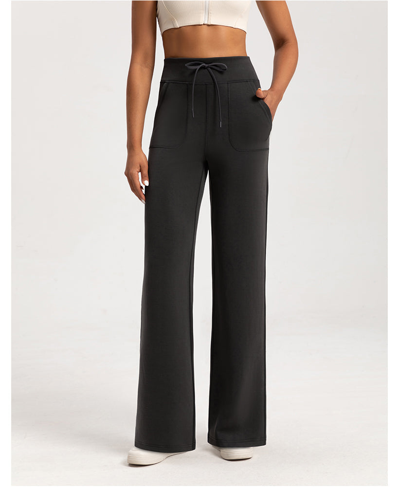 The Aura Washed Air-layer Loose Yoga Pants in black with front pockets, drawstring waist, and flared legs, perfect for casual or workout wear.