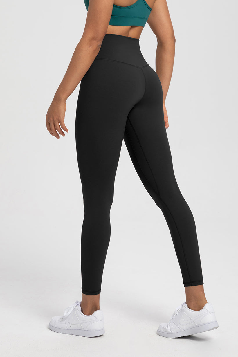 Black High-Waist Naked Feel Lycra Leggings with white sneakers, designed for yoga and Pilates with sculpting support.