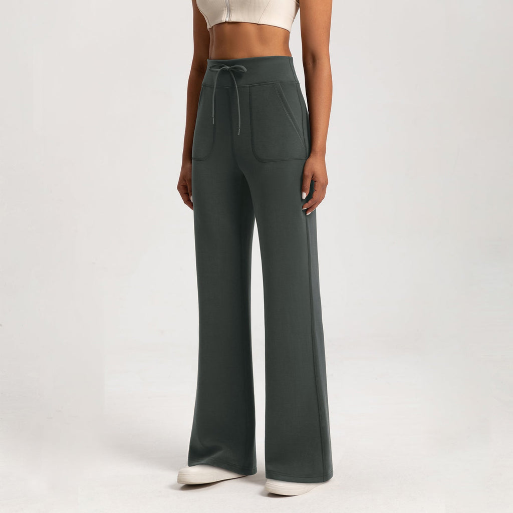 The Aura Washed Air-layer Loose Yoga Pants in dark green with wide-leg fit, drawstring waist, and front patch pockets, ideal for activewear comfort.