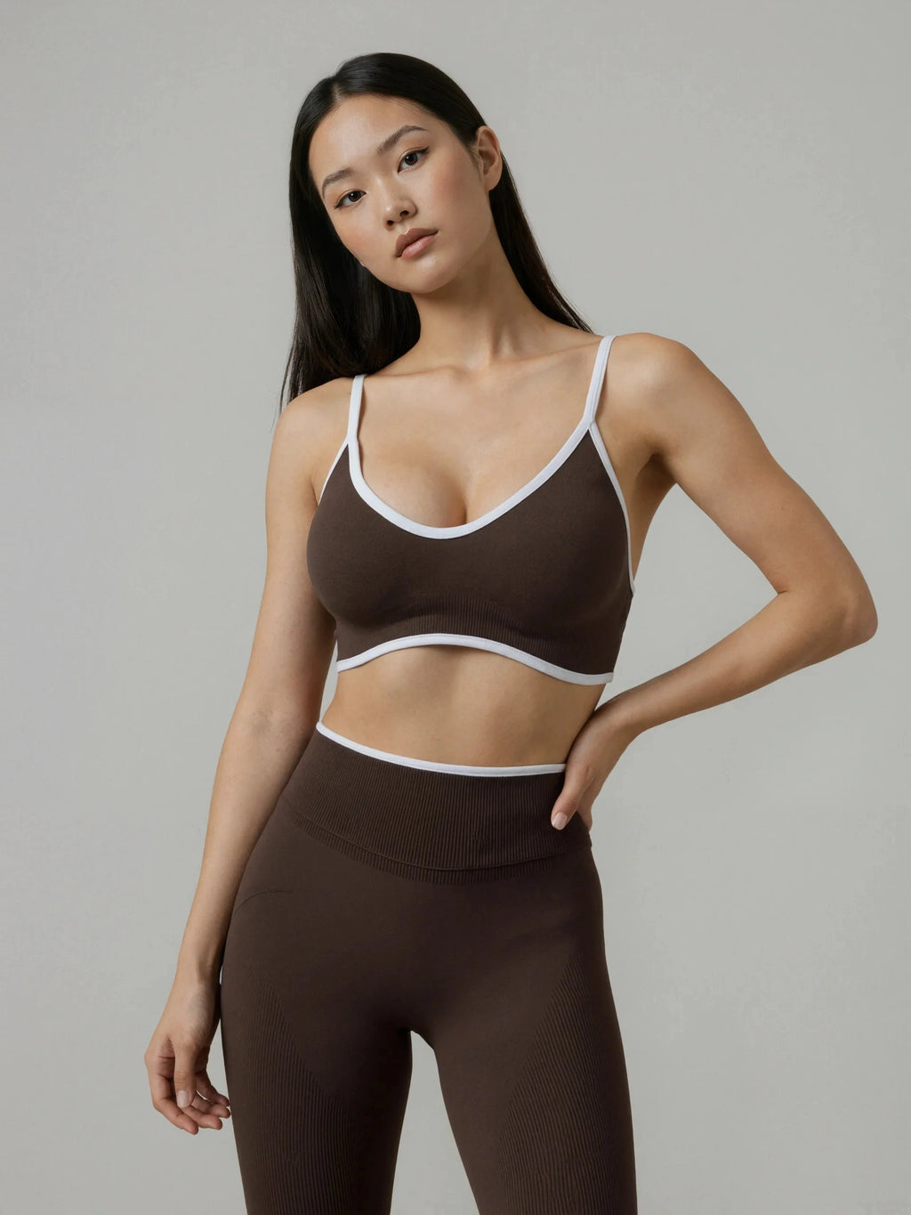 The Elevate Seamless Thin Strap Sports Bra Top in brown with white trim, paired with matching high-waisted leggings.