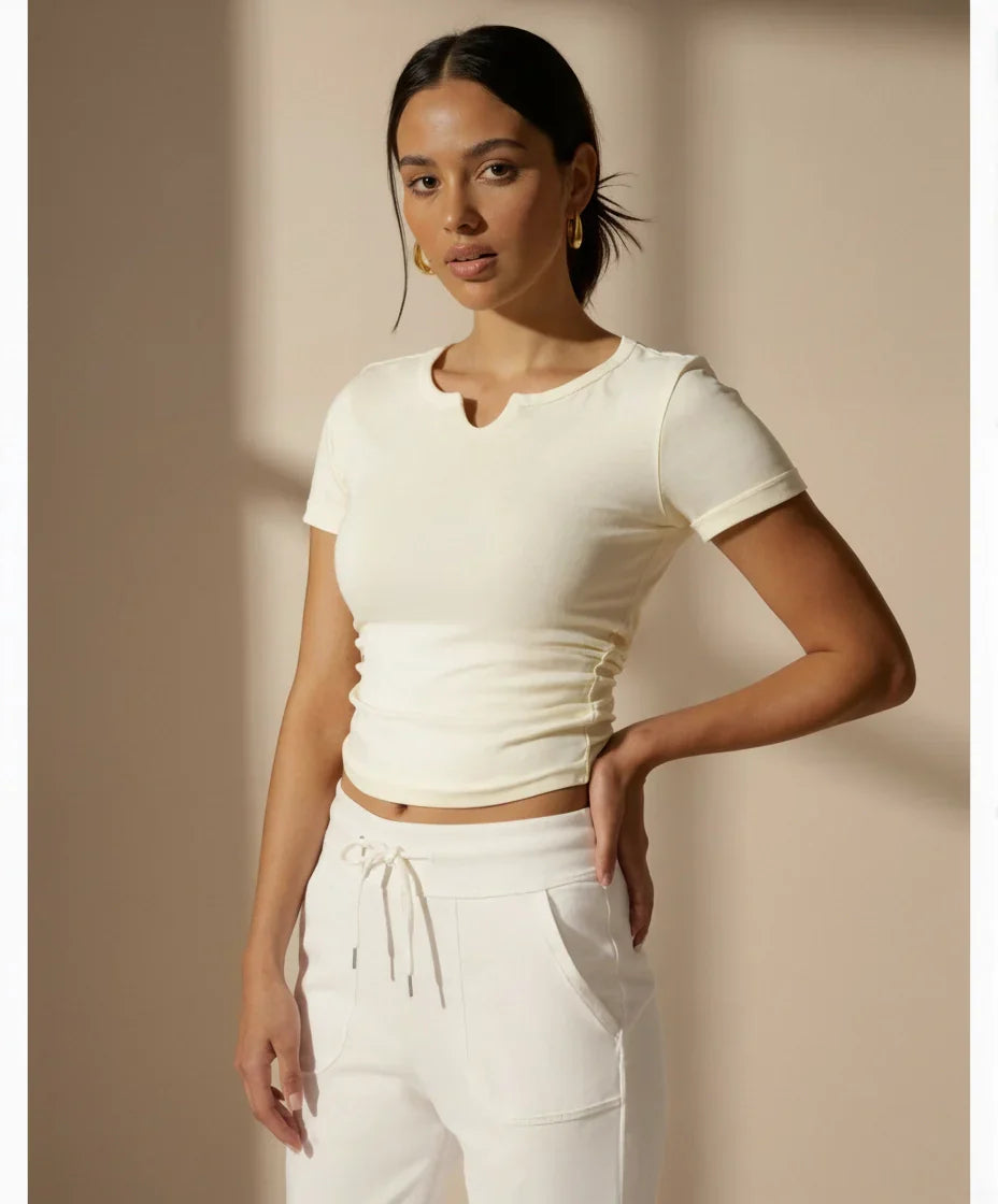 Slim Fit V-Neck Ruched Sports T-Shirt With Built-in Pads in cream, styled with matching joggers for a coordinated activewear outfit.