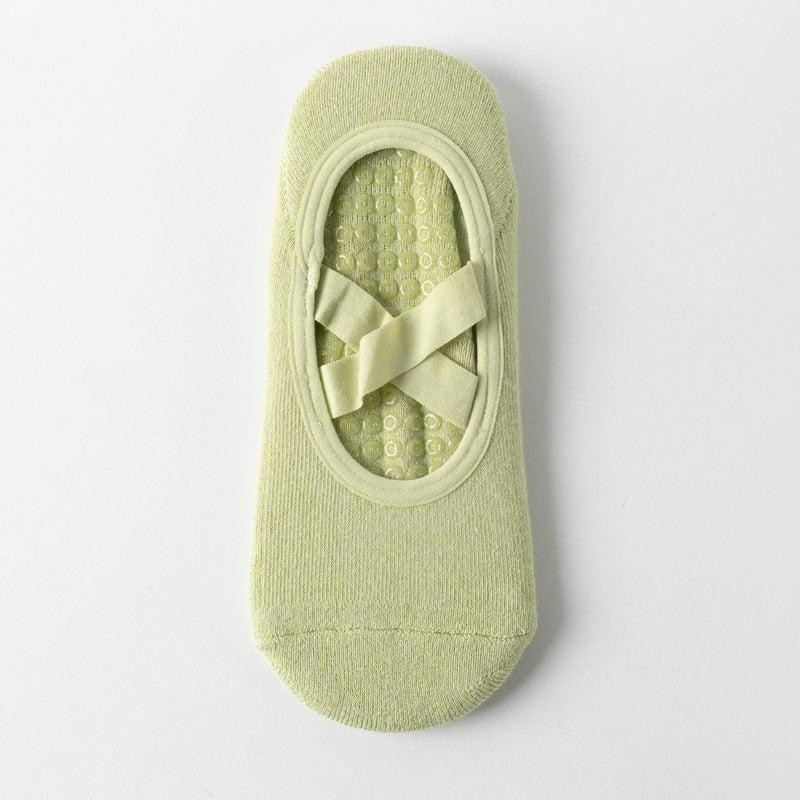 Cross-strap yoga sock in light green with 3D non-slip grip sole. Breathable, sweat-absorbent fabric ideal for stability during workouts.