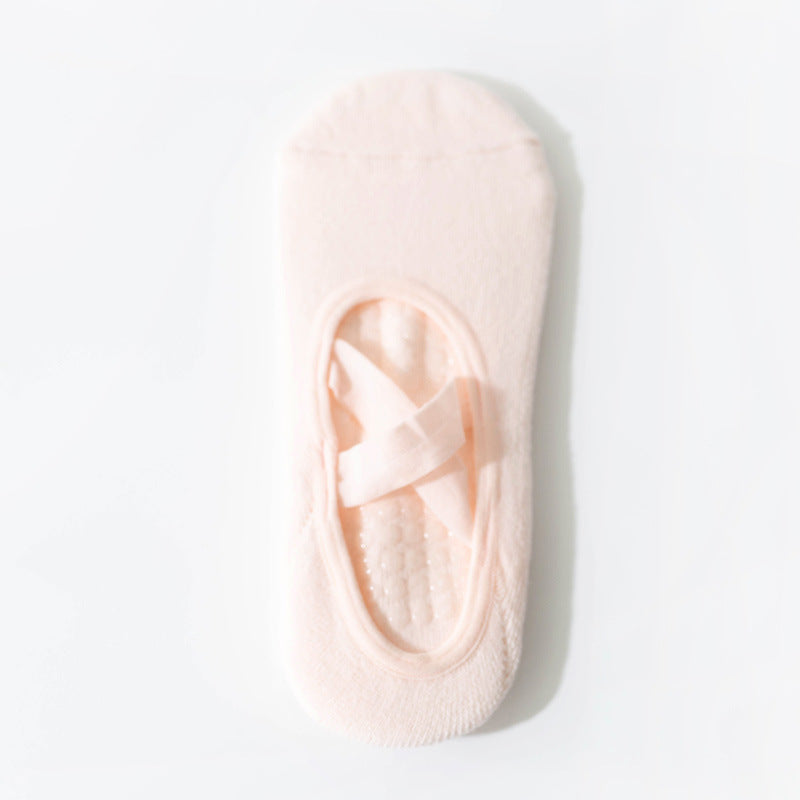 Cross-strap yoga sock in light pink with 3D non-slip grip sole. Breathable, sweat-absorbent fabric ideal for stability during workouts.