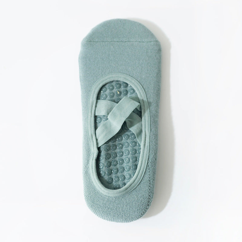 Cross-strap yoga sock in light green with 3D non-slip grip sole. Breathable, sweat-absorbent fabric ideal for stability during workouts.