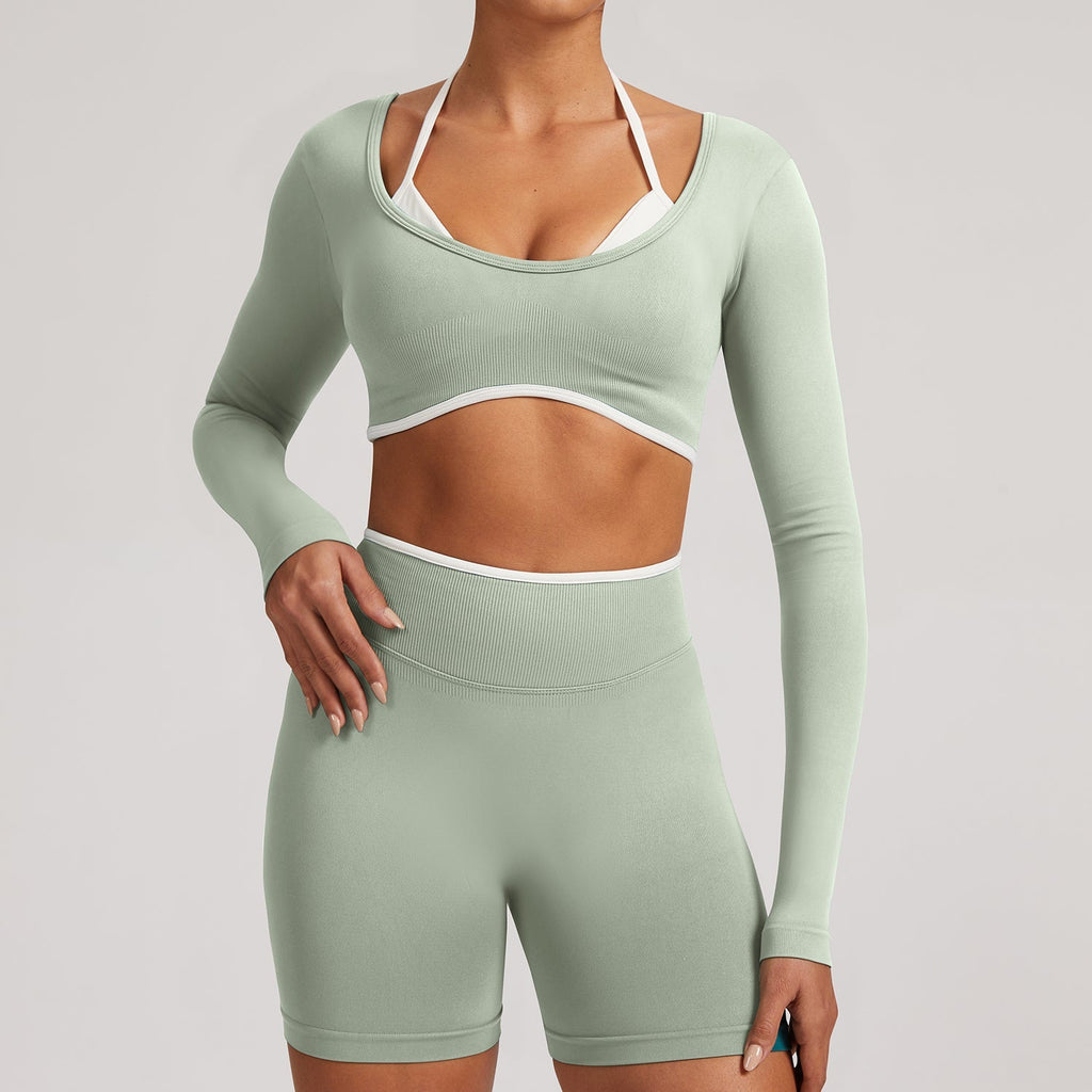 Sage green Elevate Seamless Long Sleeve & Thin Strap Sports Bra Top with white trim, paired with matching shorts for a sleek gym look.